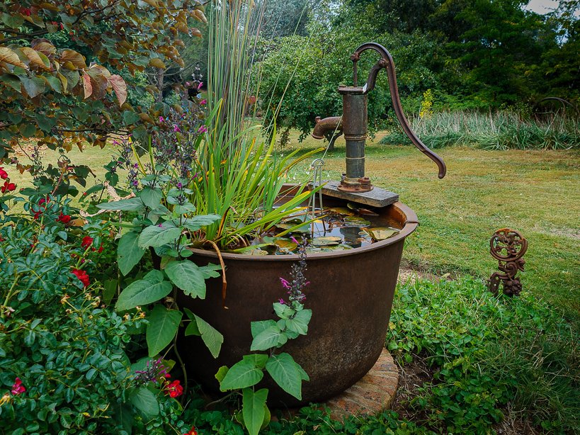 Garden feature with old tub and pump